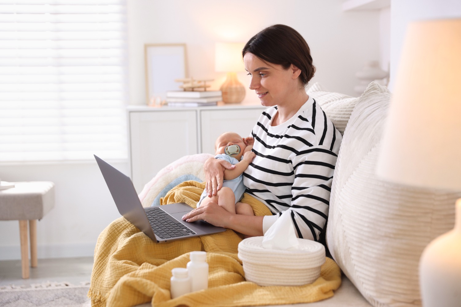 mother and baby in her lap while she is talking to lactation specialist online