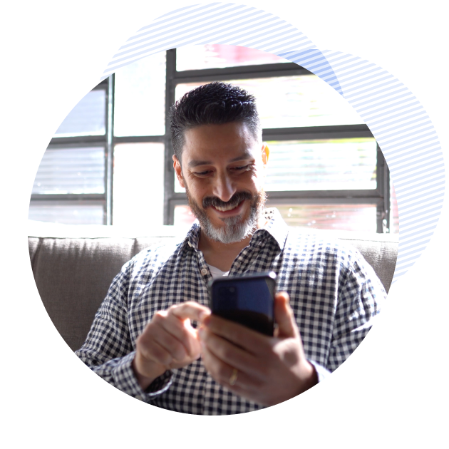 man smiling while holding his phone