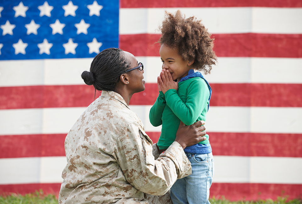 american soldier and child flag in the background