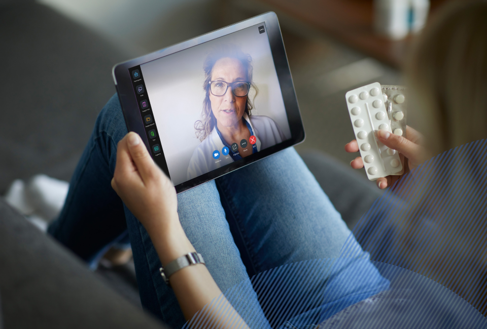 patient talking to a provider on her tablet, holding her medication